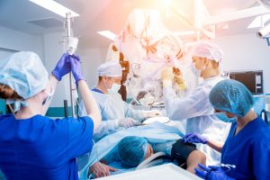 Spinal surgery. Group of surgeons in operating room with surgery equipment. Laminectomy. Modern medical background; blog: Traditional Open Surgery vs Minimally Invasive Spine Surgery